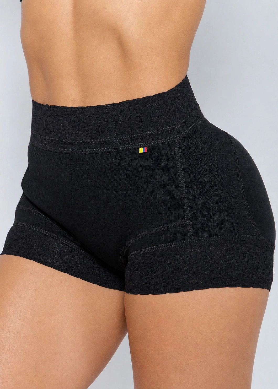 Black high-waisted compression or shapewear shorts with lace trim at the waistband and leg hems, shown on a model from the back against a light gray background.